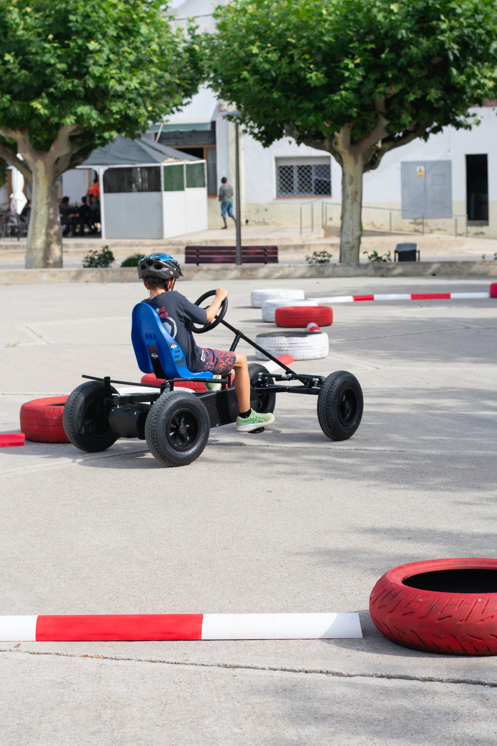 Dos niños conduciendo un kart a pedales dentro del circuito