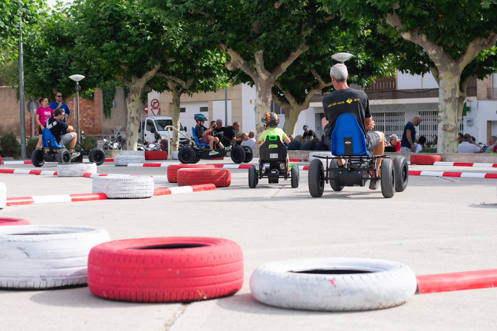 Niños recorriendo un circuito de karts a pedales en una plaza