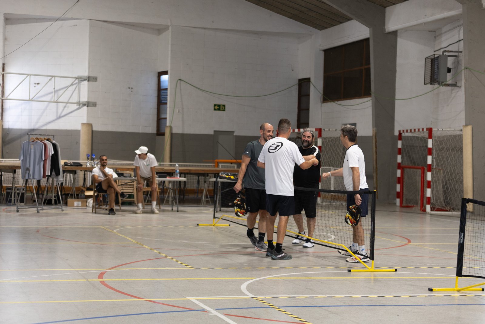 Participantes jugando pickleball en un pabellón municipal